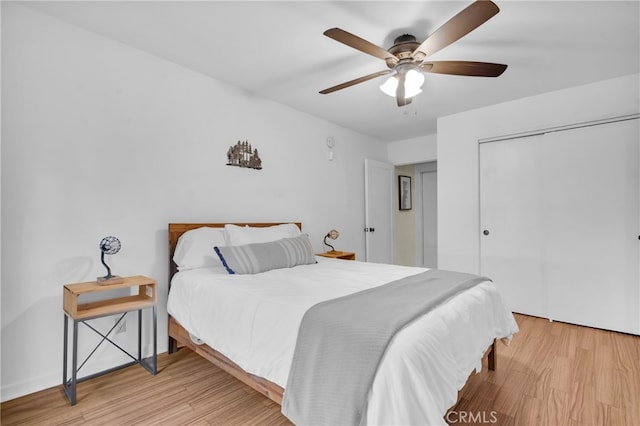 bedroom with a closet, light wood-type flooring, and ceiling fan