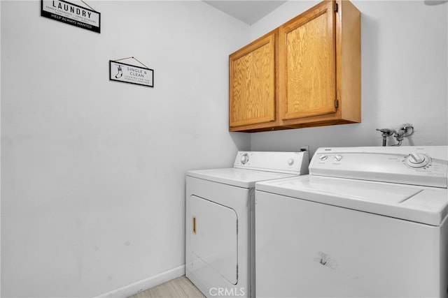 laundry room featuring washing machine and clothes dryer and cabinets