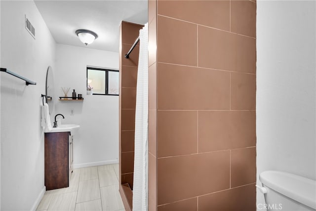 bathroom with a textured ceiling, a shower with shower curtain, toilet, vanity, and tile patterned flooring