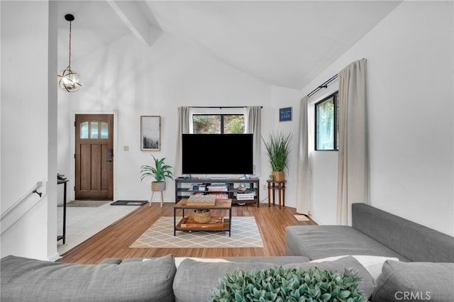 living room featuring light hardwood / wood-style floors, high vaulted ceiling, and beam ceiling