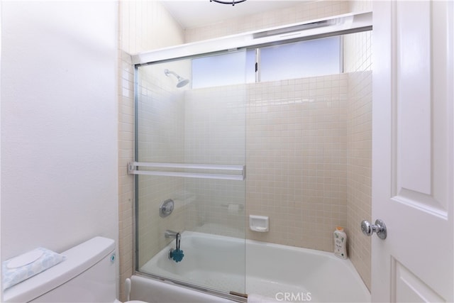 bathroom featuring shower / bath combination with glass door and toilet