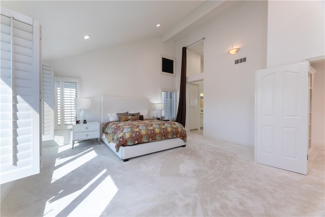 bedroom with light carpet and high vaulted ceiling