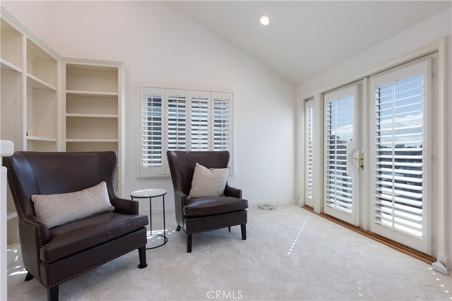 sitting room with vaulted ceiling and carpet floors