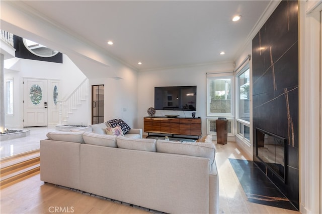 living room featuring crown molding and light wood-type flooring