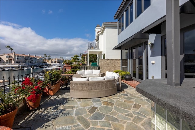 view of patio / terrace with outdoor lounge area, a water view, and a balcony