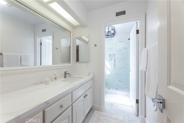 bathroom with a tile shower and vanity