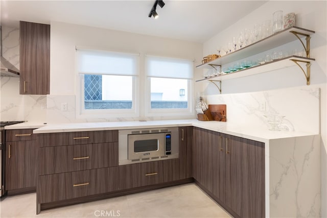 kitchen with white microwave, rail lighting, and tasteful backsplash