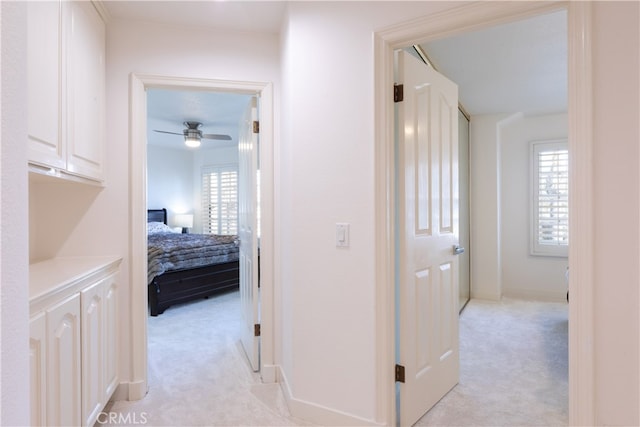 corridor featuring a wealth of natural light and light carpet