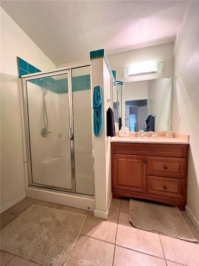 bathroom featuring tile patterned flooring, vanity, and an enclosed shower