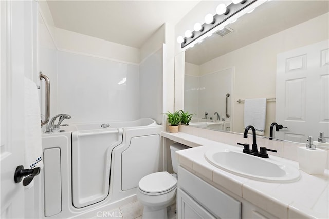 bathroom featuring tile patterned floors, vanity, a bathtub, and toilet