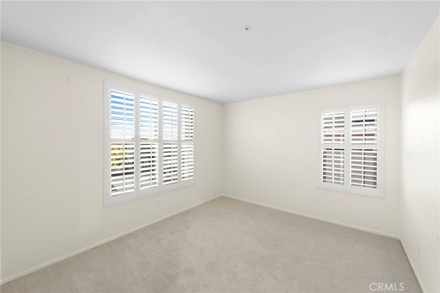 unfurnished room featuring light colored carpet