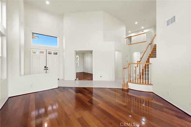 foyer with wood-type flooring and a high ceiling