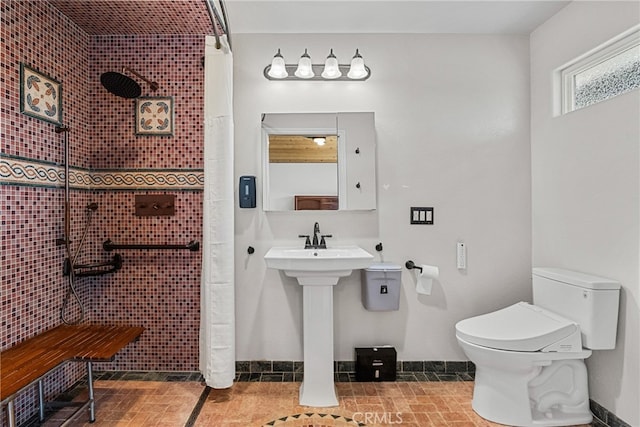 bathroom featuring a tile shower and toilet