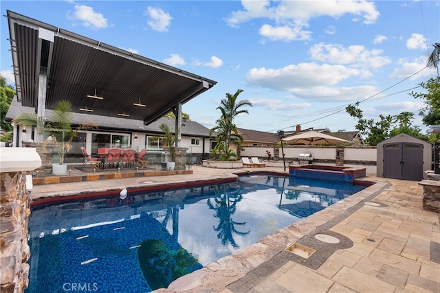 view of pool featuring a patio area, an in ground hot tub, and a storage unit