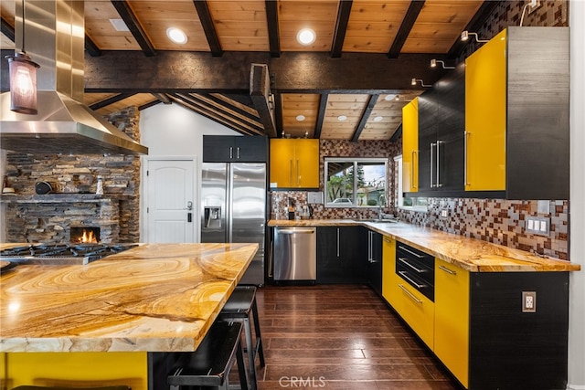 kitchen featuring butcher block counters, dark hardwood / wood-style floors, exhaust hood, stainless steel appliances, and lofted ceiling with beams