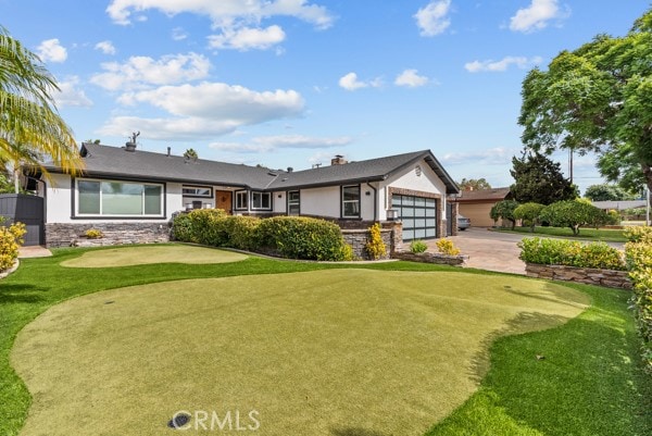 single story home featuring a front yard and a garage