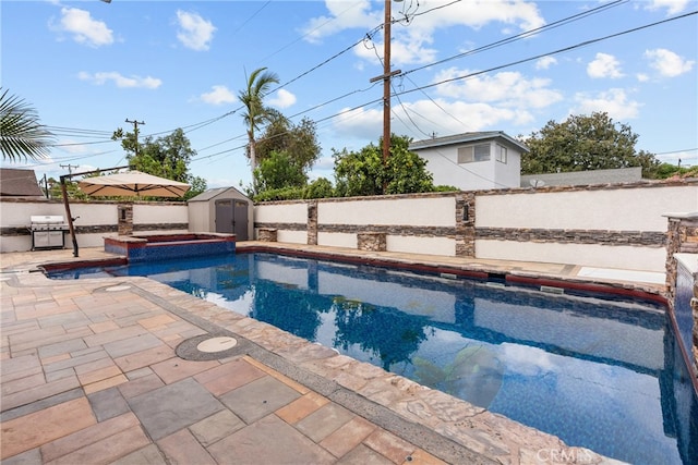 view of pool with a shed and a patio area