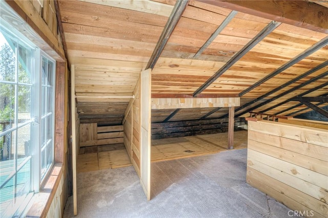 unfurnished bedroom with vaulted ceiling, wooden ceiling, and wooden walls