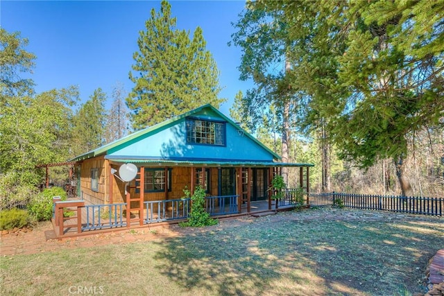 back of house featuring a yard and covered porch