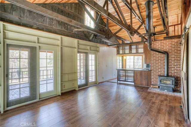 unfurnished living room with wood ceiling, wood-type flooring, high vaulted ceiling, and a wood stove