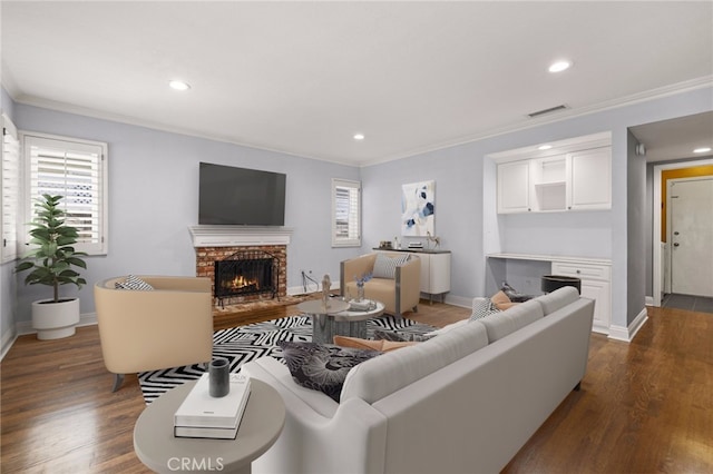 living room featuring dark hardwood / wood-style flooring, ornamental molding, and a brick fireplace