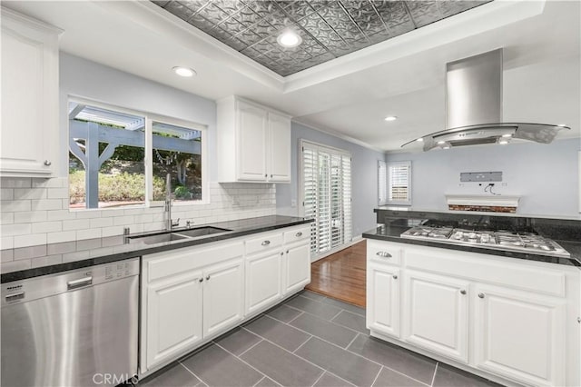 kitchen featuring sink, island exhaust hood, crown molding, white cabinets, and appliances with stainless steel finishes