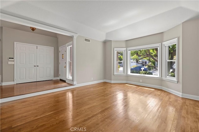 interior space with wood-type flooring and decorative columns