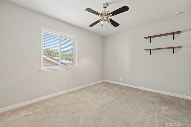 carpeted spare room featuring ceiling fan