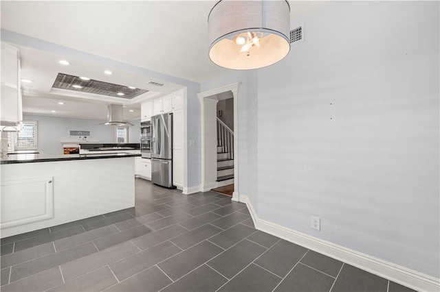 kitchen with white cabinets, a raised ceiling, sink, kitchen peninsula, and stainless steel refrigerator