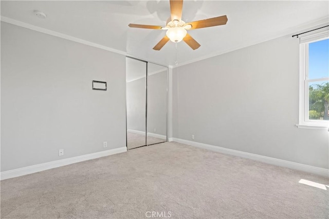 unfurnished bedroom with ceiling fan, light carpet, and a closet