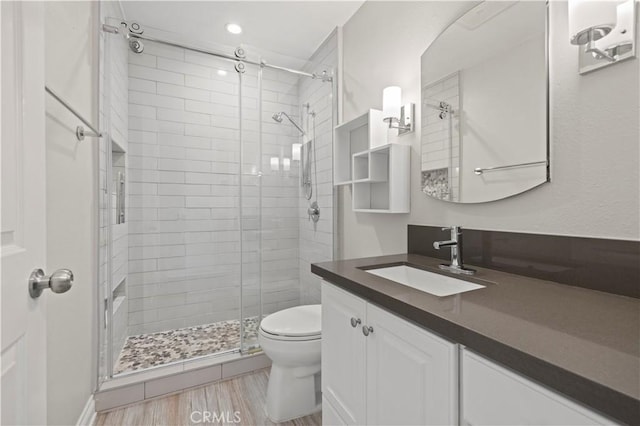 bathroom featuring vanity, toilet, and walk in shower