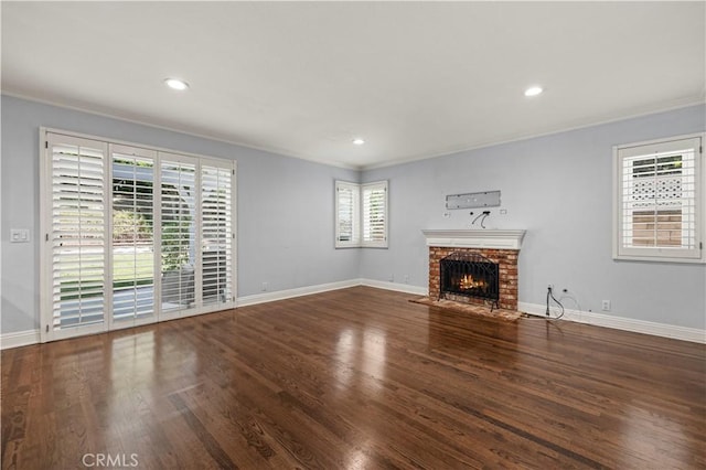 unfurnished living room with crown molding, dark hardwood / wood-style flooring, and a brick fireplace