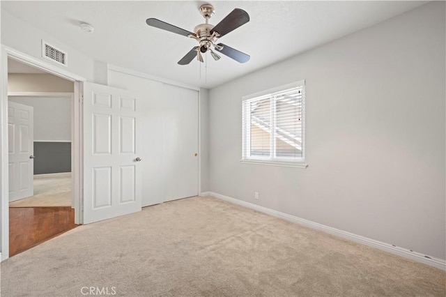 unfurnished room with ceiling fan and light colored carpet