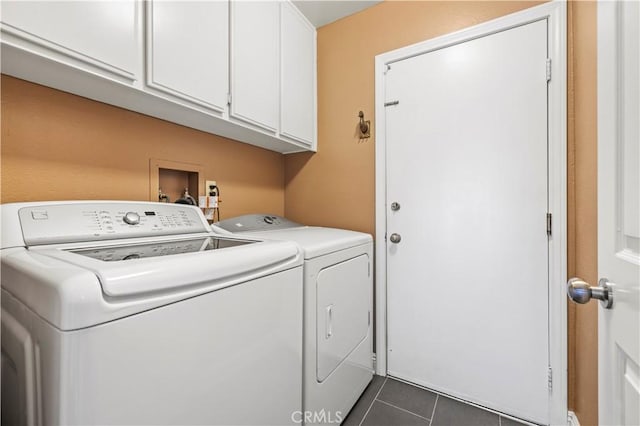 clothes washing area featuring dark tile patterned floors, cabinets, and independent washer and dryer