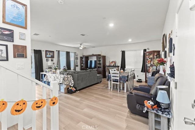 living room featuring light hardwood / wood-style flooring and ceiling fan