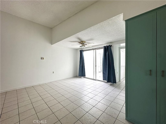 tiled spare room featuring a textured ceiling and ceiling fan