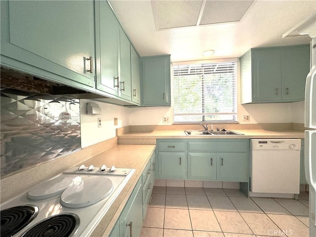 kitchen with green cabinets, sink, light tile patterned floors, and white appliances