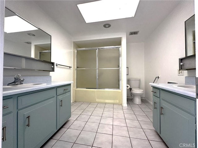 full bathroom featuring tile patterned flooring, toilet, enclosed tub / shower combo, and a skylight