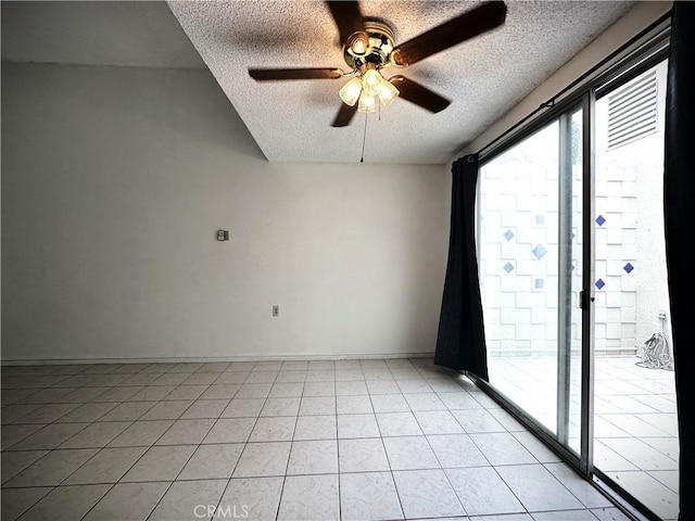 empty room with light tile patterned floors, a textured ceiling, and ceiling fan