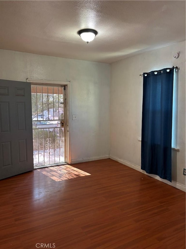 empty room featuring hardwood / wood-style flooring and a textured ceiling