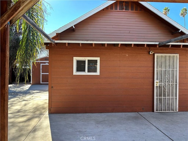 view of home's exterior with a patio area and a shed