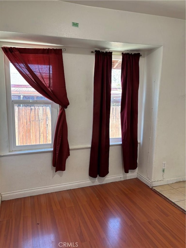 empty room with a healthy amount of sunlight and wood-type flooring