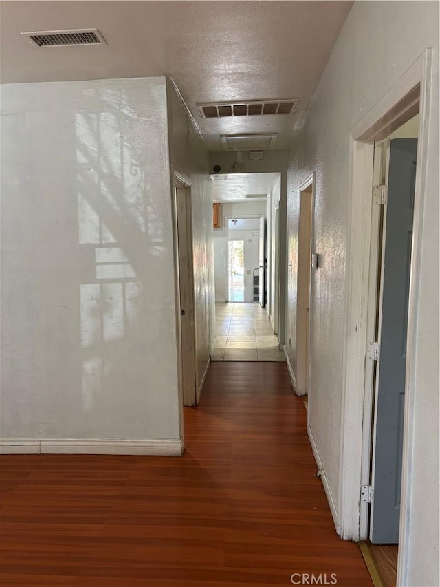 hallway featuring hardwood / wood-style flooring and a textured ceiling