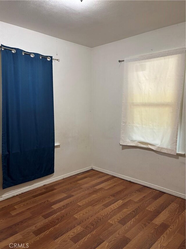 spare room featuring dark hardwood / wood-style flooring