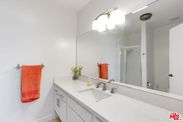 bathroom featuring vanity, toilet, and an enclosed shower