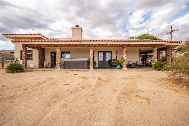 mediterranean / spanish home featuring a patio area and french doors