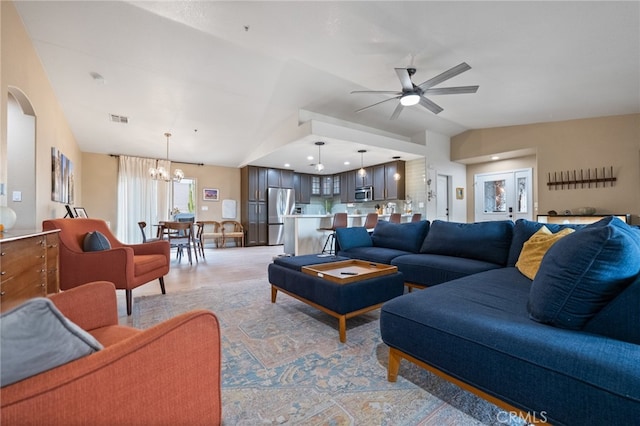 living room with vaulted ceiling and ceiling fan with notable chandelier