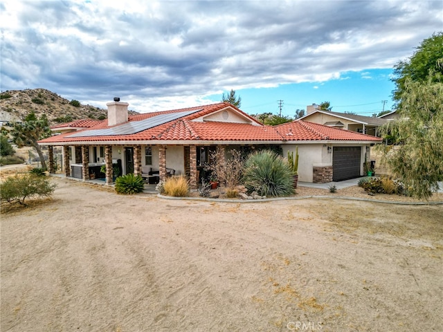 ranch-style home with a porch and a garage