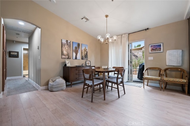 dining room with vaulted ceiling, light hardwood / wood-style flooring, and a notable chandelier