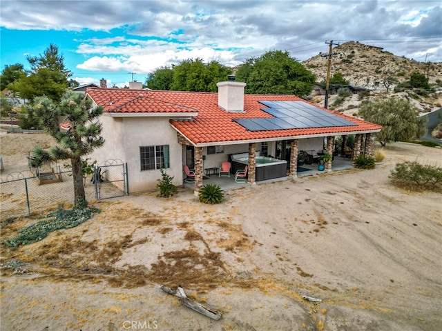 rear view of property with a hot tub